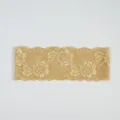 Gros plan détaillé de la belle bordure en dentelle élastique champagne au motif floral. - Or champagne