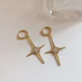 Detailed close-up view of trendy gold-plated four-pointed star hoop earrings with sparkling zircon. - Color-Preserving Gold Hoops
