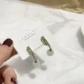 Detaillierte Nahaufnahme von eleganten Kristall-Doppelsteg-Ohrringen mit weißen Perlen und Karte. - Katzenaugen-Stil mit Strass