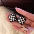 Close-up detail shot of retro black and white checkerboard square earrings with dark border. - Square Checkerboard Black