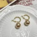 Gold C-shape hoop earrings with large champagne pearl pendants, elegant and stylish jewelry. - Champagne Hoops