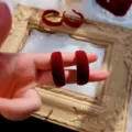 Red velvet hoop earrings detail shot showcasing texture, retro fashion autumn winter jewelry accessory - Burgundy