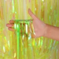 Détail de rideau à franges métallisées arc-en-ciel brillant pour décoration de fête. - Jaune
