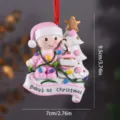 Cute resin Christmas baby ornament with lights and tree, perfect for holiday tree hanging decor. - Pink Baby