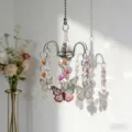 Detailed view of crystal suncatcher with metal butterflies and prism beads casting rainbow light. - Butterfly Charms with Claw Settings