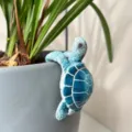 Gros plan d'une tortue de mer en résine bleue sur un pot, charmante déco de jardin. - Tortue Bleu