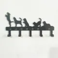 Vista dettagliata del gancio da parete in metallo nero con simpatiche silhouette di cani. - Gancio per cuccioli B