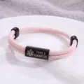 Primo piano dettagliato del braccialetto medico intrecciato rosa con tubo in acciaio inossidabile. - Stile Allerta Medica / Corda Rosa Hardware Nero