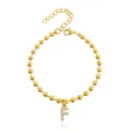 Dettaglio del bracciale di perle dorate con ciondolo lettera F tempestato di cristalli. - Braccialetto a Sfere Iniziale F con Strass / Oro