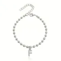 Vista di dettaglio di un bracciale in perle d'acciaio inossidabile con ciondolo lettera F. - Braccialetto a Sfere Iniziale F con Strass / Argento