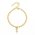Primo piano dettagliato del braccialetto di perle dorate con ciondolo a lettera. - Braccialetto a Sfere Iniziale I con Strass / Argento