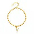 Bracciale di perle dorate con ciondolo lettera V in strass, gioiello moda in acciaio per donna. - Braccialetto a Sfere Iniziale V con Strass / Oro