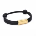 Detailed close-up showing the polished gold stainless steel tube on the black braided paracord bracelet. - 2cm Square Tube Paracord Style / Black Rope Gold Accessory