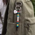 Close up shot of a colorful beaded keychain featuring 2026 charms and a heart pendant in daily use. - 2026 Heart Compass Pendant