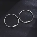 Stainless steel spring couple bracelets featuring sun and moon symbol plaques in detail. - 1 Pair Sun and Moon Pattern Spring Bracelets / Silver
