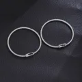 Stainless steel spring couple bracelets detailed shot, minimalist fashion jewelry pair. - 1 Pair Couples Sun and Moon Pattern Spring Bracelets / Silver