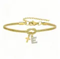 Dettaglio del bracciale a catena serpente dorata con nodo, croce e ciondolo con lettera E. - Bracciale Nodo Concentrico Croce Strass Stile E / Oro