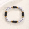 Detailed view of white stone and black bead bracelet with gold spacers for women and men fashion. - Tourmaline White Turquoise Bracelet