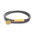 Bracciale in corda intrecciata con ciondolo rotondo in acciaio e barra magnetica dorata. - Perimetro 40cm / Corda Grigia Accessorio Oro (ZR20250715B4)
