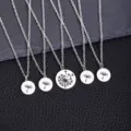 Gros plan sur des pendentifs ronds en acier inoxydable argenté aux motifs de pissenlit. - Ensemble Collier Disque Pissenlit 5 Pièces