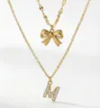 Collana a doppio strato con fiocco dorato e ciondolo lettera M in strass da donna, elegante. - Set da 2 pezzi - Stile Fiocco Lettera M / Oro