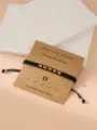 Black braided Morse code number bracelet with gold metal beads on display card for men and women - Morse Code 0 Black Flat Knot Bracelet with Card