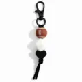Close-up detail of sports style rugby bead keychain with black tassel and metal clasp. - Rugby Ball