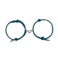 Close-up van bijpassende teal gevlochten koppelarmbanden met magnetische hartbedels. - Hart Pauwenblauw Paar