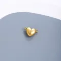 Primo piano di una chiusura magnetica a cuore dorata in acciaio per gioielli. - Oro