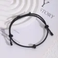 Nahaufnahme Detail des schwarzen verstellbaren Kordelarmbands mit Zahnrad und Metallenden. - Schwarz