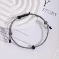 Graues Survival Seilarmband mit schwarzem Zahnradwerkzeug und verstellbarem Knoten. - Grau