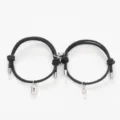 Close-up detail of magnetic couple bracelets featuring lock and key pendants on black cord. - Key Lock Black Pair