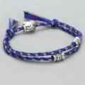 Close-up detail of the braided cotton rope bracelet with metal Buddha head bead and charms. - Buddha Head Hand Rope F2 (Blue Purple Grey)
