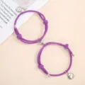 Detail of purple woven couple bracelets featuring magnetic clasp and lovely silver smiley charms. - One Pair / Purple