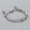 Closeup of braided cord bracelet featuring alloy buddha head and carved barrel beads details. - Buddha Head Hand Rope F4 (Grey Pink)