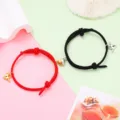 Details of couple magnetic attraction bracelets with red and black ropes and winged hearts. - Magnetic Heart Pair / 1 Pair / Black and Red