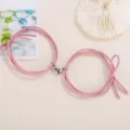 Close-up detail of couple magnetic heart braided rope bracelet in pink fashion style. - Elastic Heart Magnet Style / 1 Pair / Pink