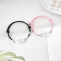 Vue détaillée de bracelets de couple assortis en corde noire et rose avec menottes aimantées. - Menottes Noir et Rose Paire
