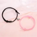 Close-up of magnetic couple heart bracelets with black and pink woven rope design details. - Simple Black & Pink Pair