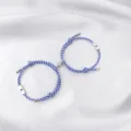 Detailed view of blue and white braided couple bracelets with magnetic sun and moon charms. - Sun & Moon / 2-Piece Set / Blue & White