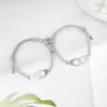 Vue détaillée de bracelets de couple magnétiques menottes tissés gris, design élégant. - Menottes Gris Paire