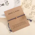 Adjustable braided cord wish bracelet with a gold metal bead on craft paper card. - Blue-Purple (F10)