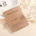 Colorful woven cotton rope bracelet with a gold-tone bead on wish card, simple adjustable jewelry. - Orange (F8)