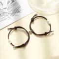 Close-up of brown braided couple bracelets with sun and moon charms and magnetic clasp detail. - Milan Cord Sun Moon Coffee Pair