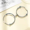 Detail view of magnetic couple bracelets featuring sun and moon charms on blue woven rope. - Multicolor Cord Sun Moon Pair
