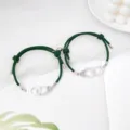 Close-up detail of green woven couple bracelets with silver handcuff charms and magnetic clasp. - Handcuff Dark Green Pair