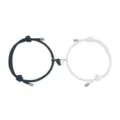 Close-up of black and white rope couple bracelets with magnetic connecting half-heart charms. - Black And White Pair