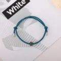 Detailed view of blue black woven survival bracelet with metal tips and tungsten bead. - Tungsten Carbide Bracelet (Metal End) / Black Blue