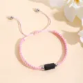 Primo piano dettagliato del bracciale intrecciato rosa fatto a mano con pietra nera. - Rosa