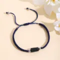 Dettaglio del bracciale intrecciato blu scuro fatto a mano con pietra di tormalina nera. - Blu navy